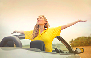 Woman enjoying convertible car ride in the summer time